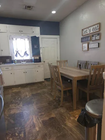 a kitchen with stainless steel appliances a table and chairs in it