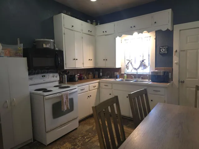 a view of a kitchen with stove top oven
