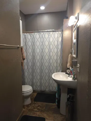 a bathroom with a sink toilet and a mirror