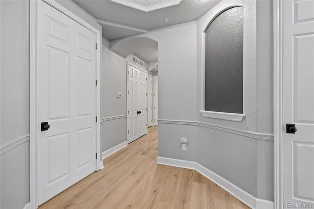 an empty room with wooden floor fireplace and windows