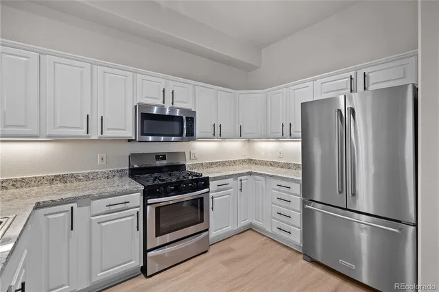 a kitchen with granite countertop a sink stove and cabinets