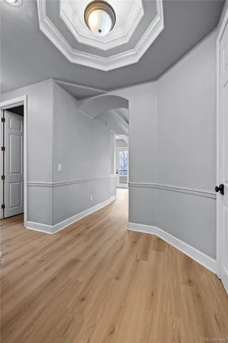 a view of a hallway with wooden floor and cabinet