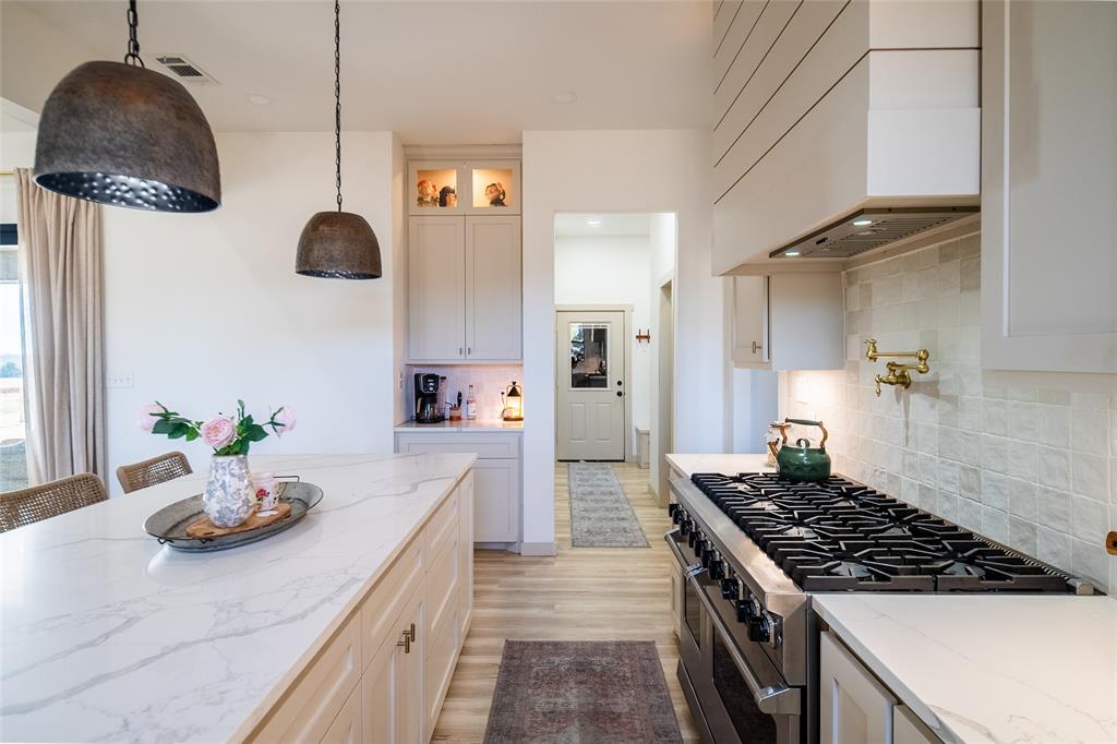 375 Wolf Front Road Van Alstyne, TX 75495 - Photo 11 of 40 a kitchen with a sink a stove and chairs