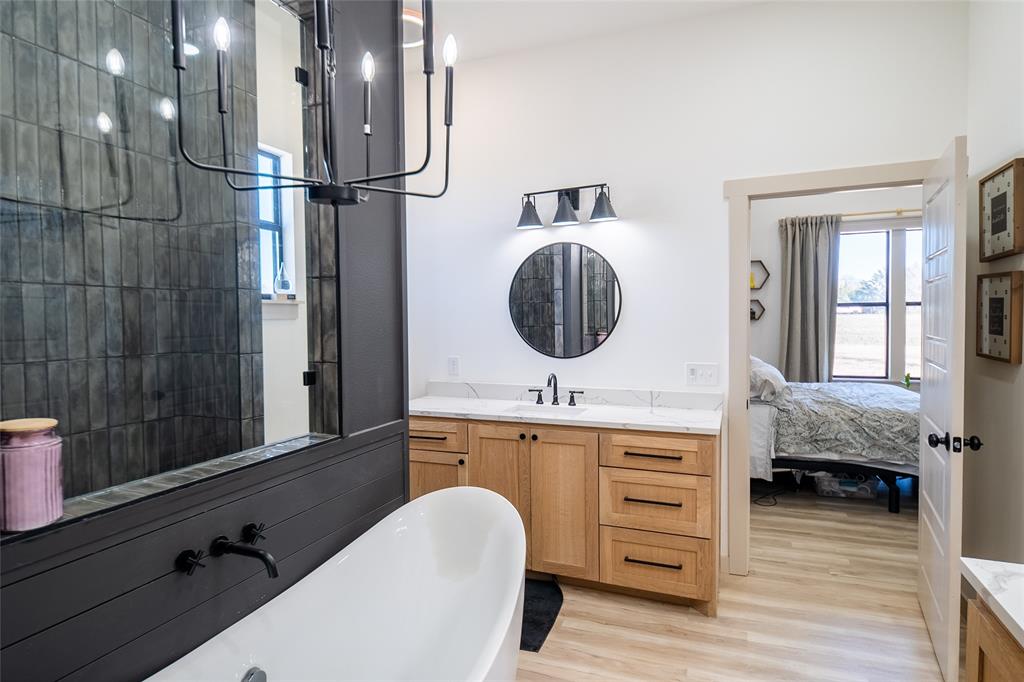 375 Wolf Front Road Van Alstyne, TX 75495 - Photo 16 of 40 a en suite bathroom with a granite countertop sink and a mirror