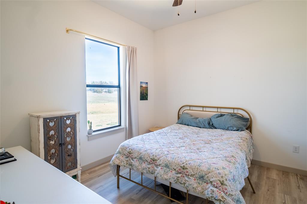 375 Wolf Front Road Van Alstyne, TX 75495 - Photo 26 of 40 a bedroom with a bed and wooden floor