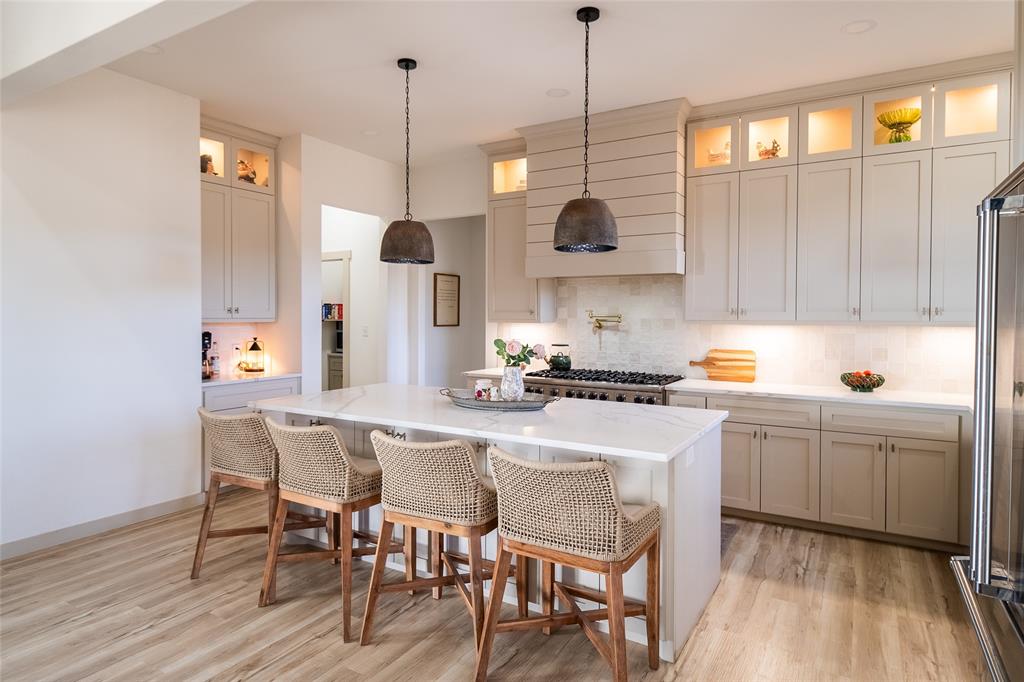 375 Wolf Front Road Van Alstyne, TX 75495 - Photo 10 of 40 a kitchen with stainless steel appliances granite countertop a sink a stove a refrigerator and island with wooden floor