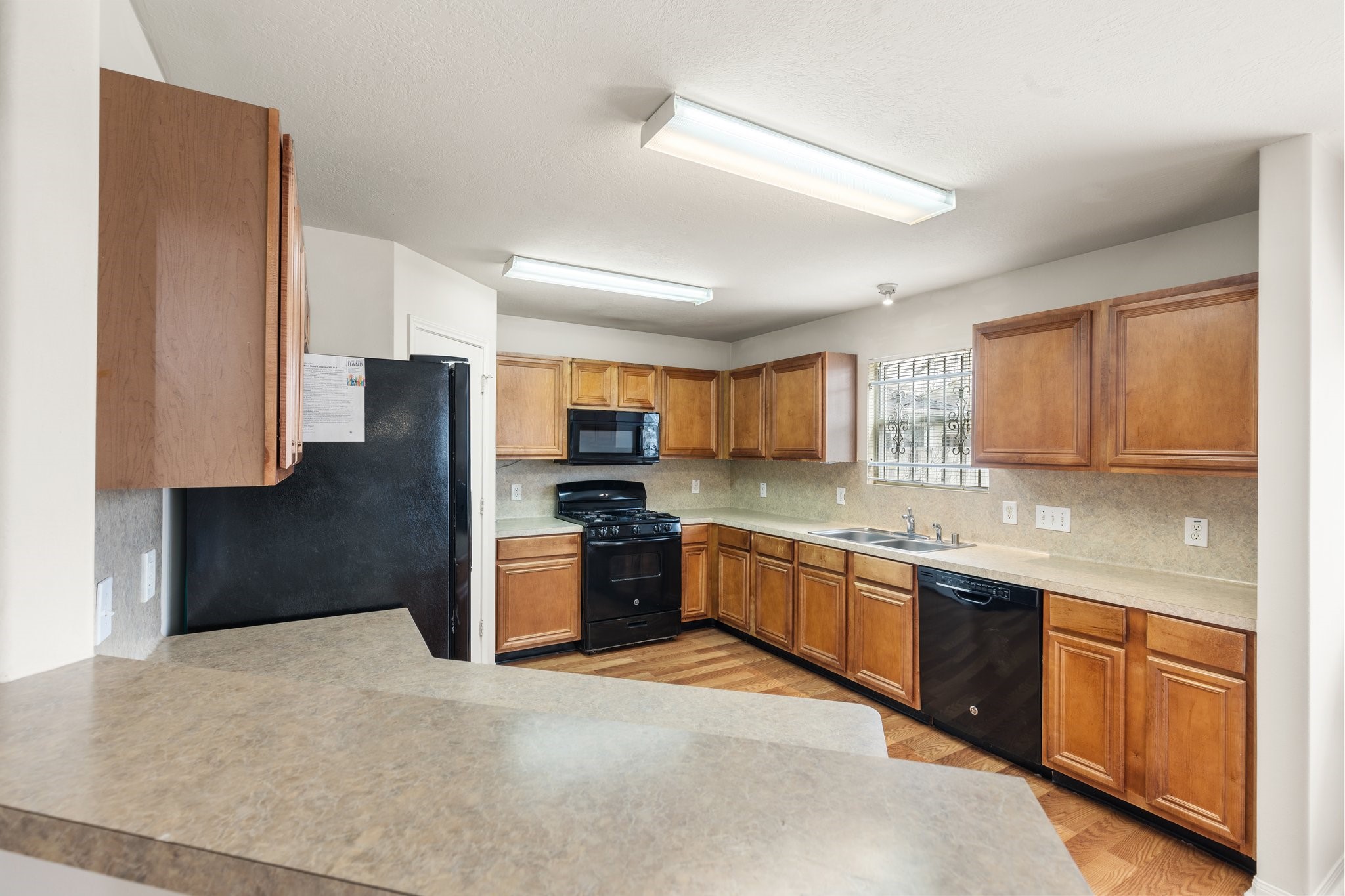 3111 Holly Ranch Drive Katy, TX 77494 - Photo 8 of 28 a large kitchen with stainless steel appliances granite countertop a refrigerator a sink dishwasher a stove with wooden cabinets and floor