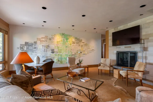 a dining room with furniture large windows and a chandelier
