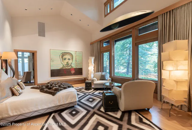 a living room with furniture a large window and a chandelier
