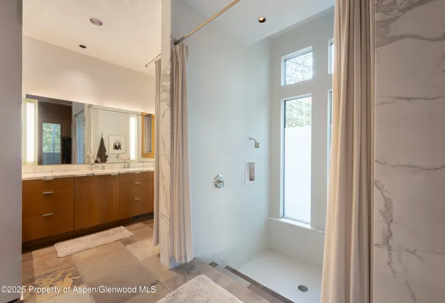 a view of a patio with table and chairs under an umbrella with a small yard