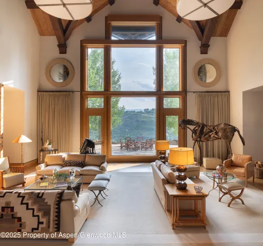 a living room with fireplace furniture and a large window