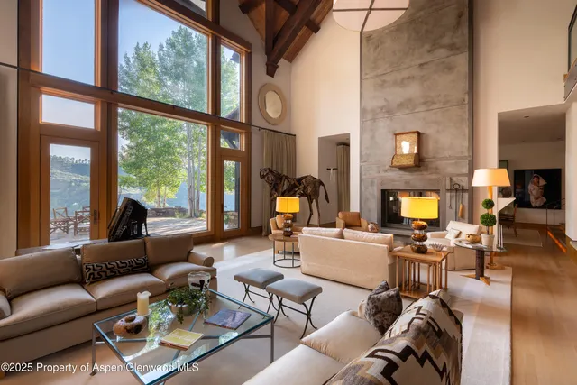 a living room with fireplace furniture and a large window