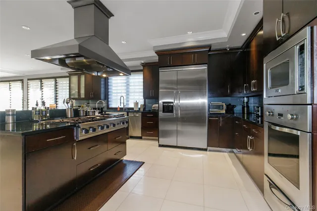 a kitchen with stainless steel appliances granite countertop a stove a sink and a refrigerator