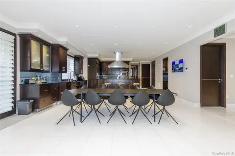 a open kitchen with stainless steel appliances kitchen island granite countertop a refrigerator a stove a oven with white cabinets and chairs