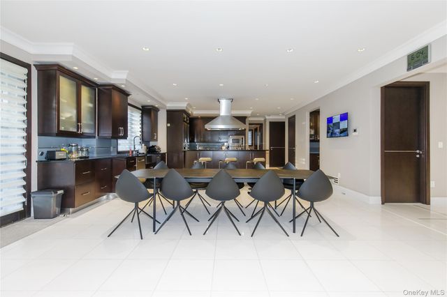 a open kitchen with stainless steel appliances kitchen island granite countertop a refrigerator a stove a oven with white cabinets and chairs