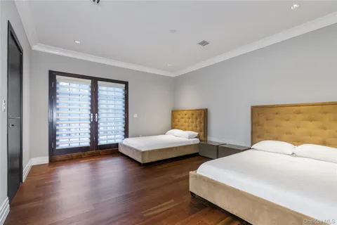 a bedroom with two beds and a large window