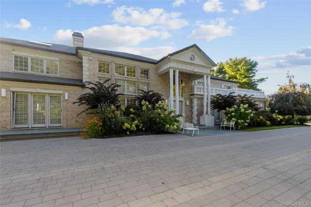 a front view of house with yard and trees in the background