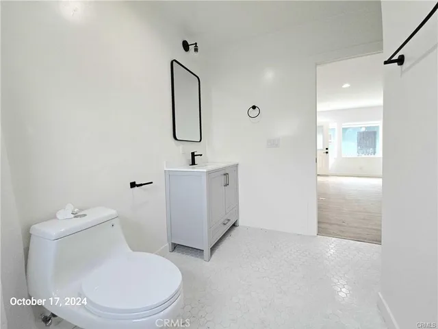 a white toilet sitting next to a bathroom sink and a mirror