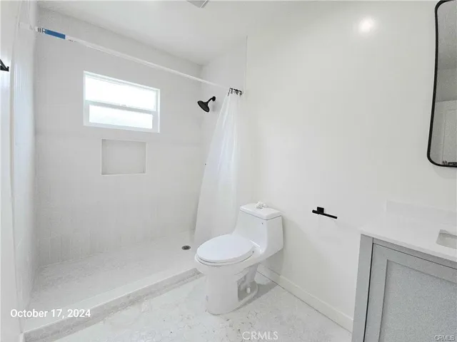 a white toilet sitting next to a bath tub shower