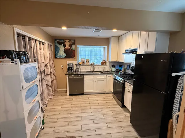 a kitchen with stainless steel appliances granite countertop a stove a sink dishwasher and a refrigerator