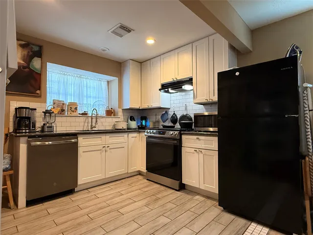 a kitchen with a refrigerator stove top oven and sink