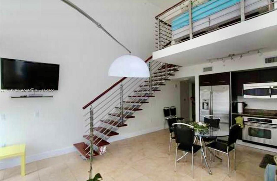 41 Southeast 5th Street, Unit 702 Miami, FL 33131 - Photo 13 of 23 a living room with furniture and a flat screen tv