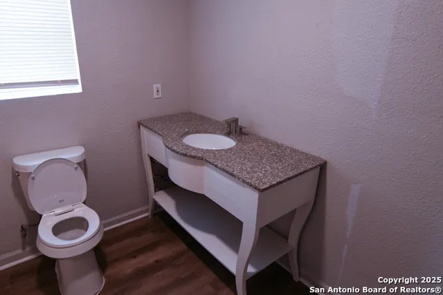 a bathroom with a toilet a sink and a window