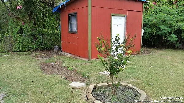 a flower plants in front of yellow house