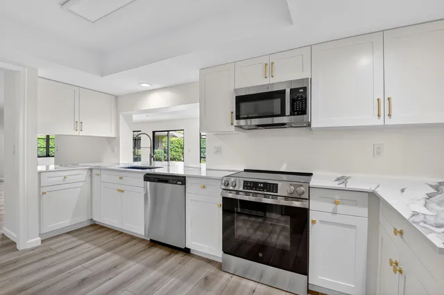 a kitchen with white cabinets and appliances