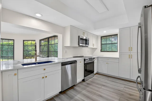 a kitchen with white cabinets and appliances