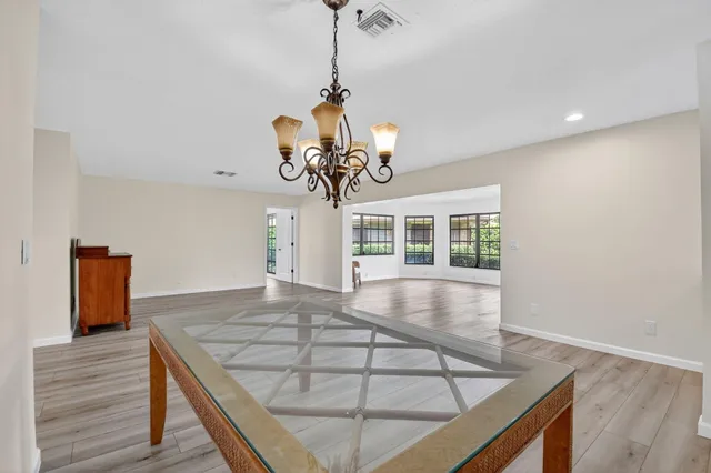 a room with wooden floor and chandelier