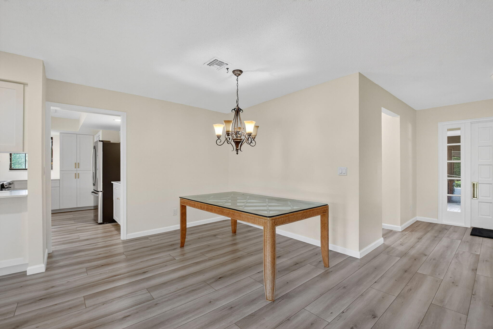 600 Cypress Key Drive Atlantis, FL 33462 - Photo 25 of 43 a room with wooden floor and chandelier