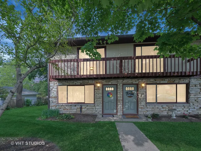a view of a house with a small yard and a large tree