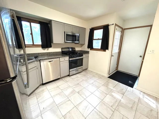a kitchen with stainless steel appliances a refrigerator sink and microwave