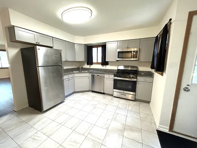 a kitchen with stainless steel appliances granite countertop a refrigerator stove and sink
