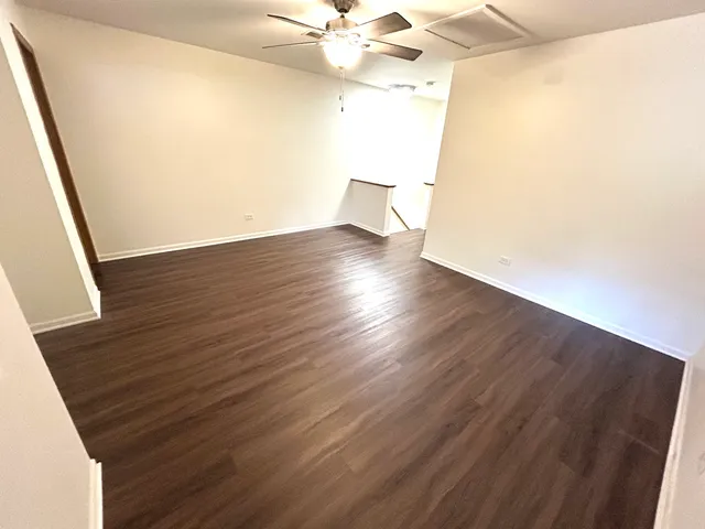 a view of a room with wooden floor and fan