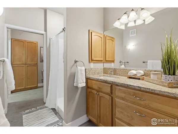 a bathroom with a granite countertop sink a mirror and a shower
