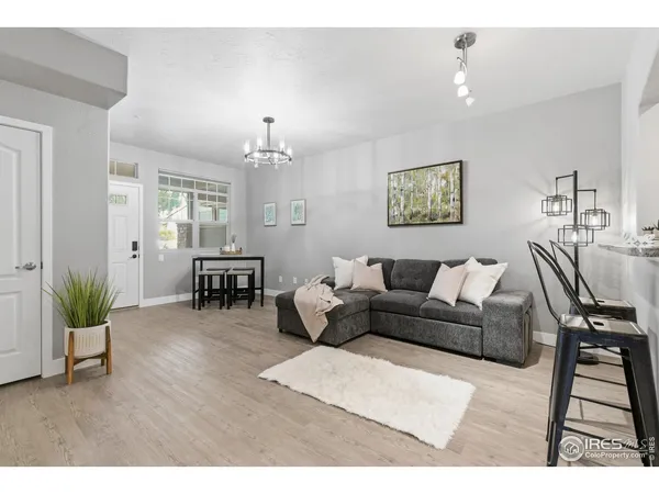 a living room with furniture and a dining table with wooden floor