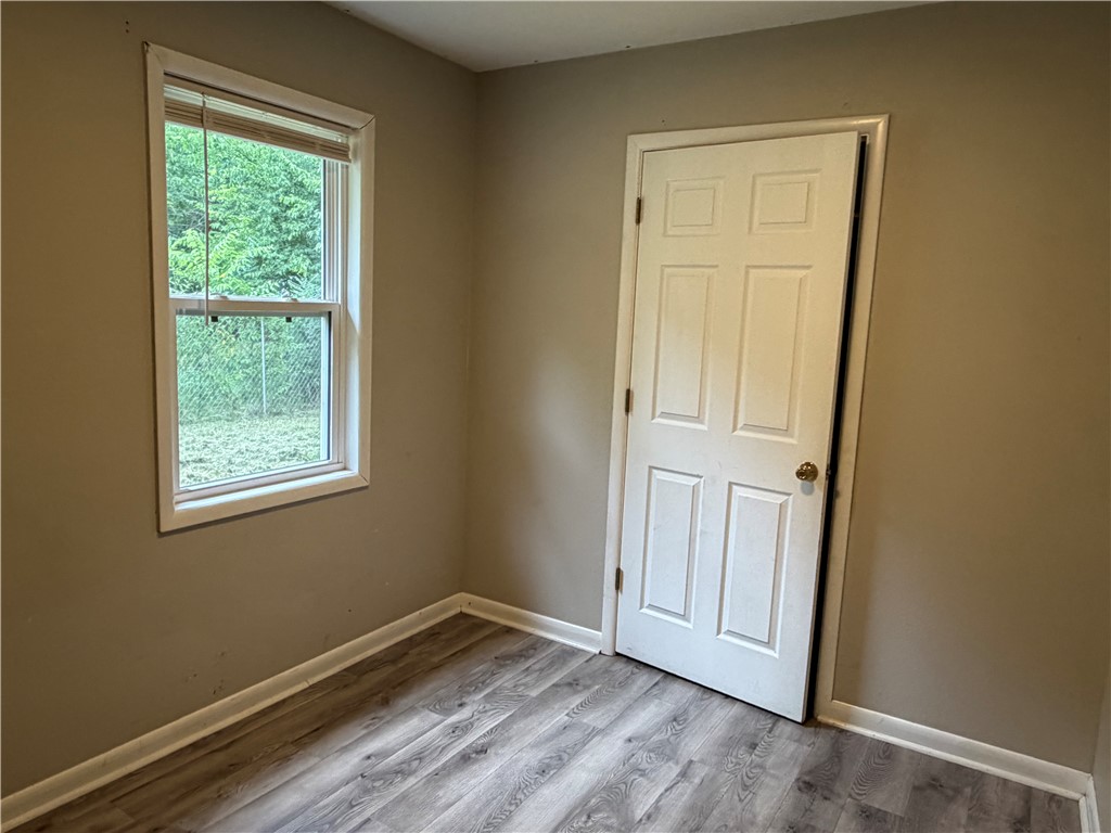 909 Riddell Street Clarksville, AR 72830 - Photo 19 of 26 Neutral wall color with wood-finish flooring