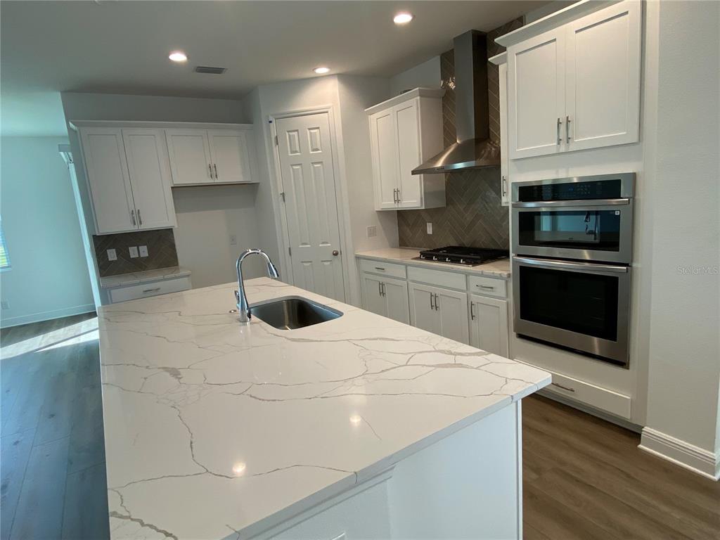 435 Lemongrass Road Minneola, FL 34715 - Photo 3 of 21 a kitchen with stainless steel appliances a stove a sink and a refrigerator
