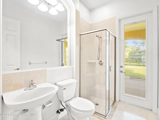 a bathroom with a granite countertop double vanity sink a mirror and a bathtub
