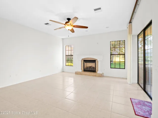 a view of an empty room with a window and a fireplace