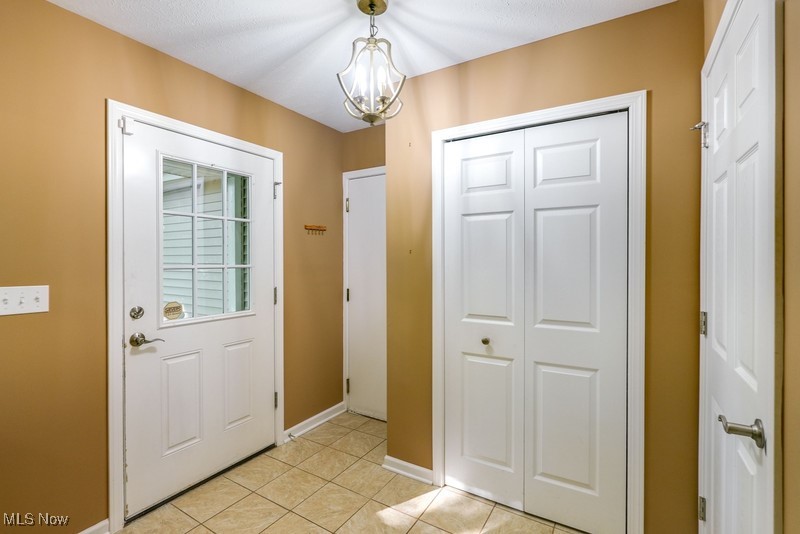 8648 Taylor May Road Chagrin Falls, OH 44023 - Photo 10 of 37 Doorway with light tile patterned floors and a notable chandelier