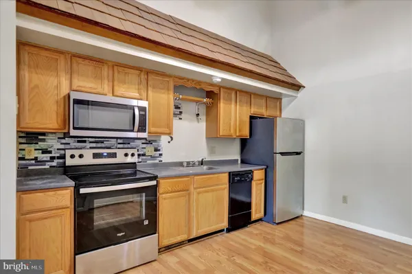 a kitchen with stainless steel appliances a stove microwave and refrigerator