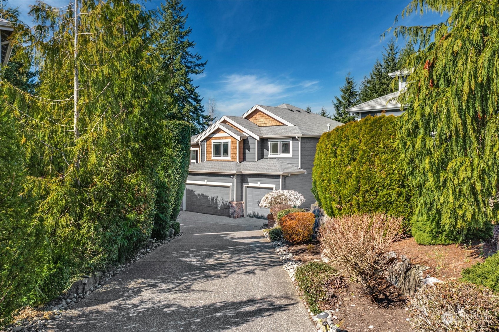 4405 240 Place Southeast Bothell, WA 98021 - Photo 1 of 1 a view of a white house with a yard and lawn chairs under an umbrella