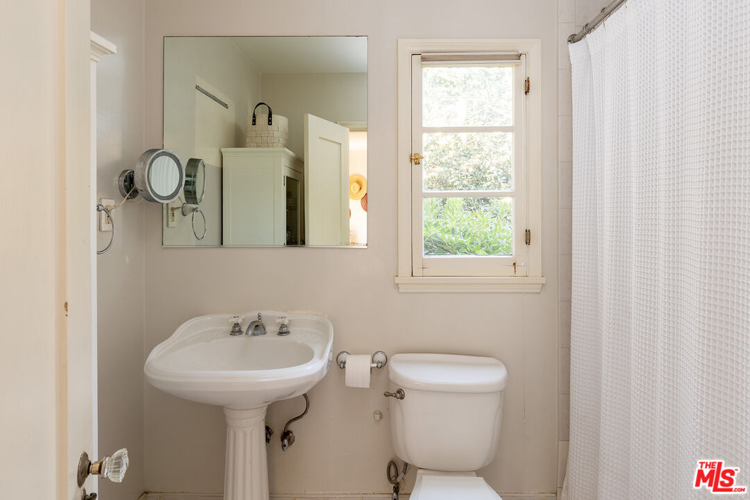 10346 Rochester Avenue Los Angeles, CA 90024 - Photo 15 of 19 a bathroom with a toilet sink and mirror