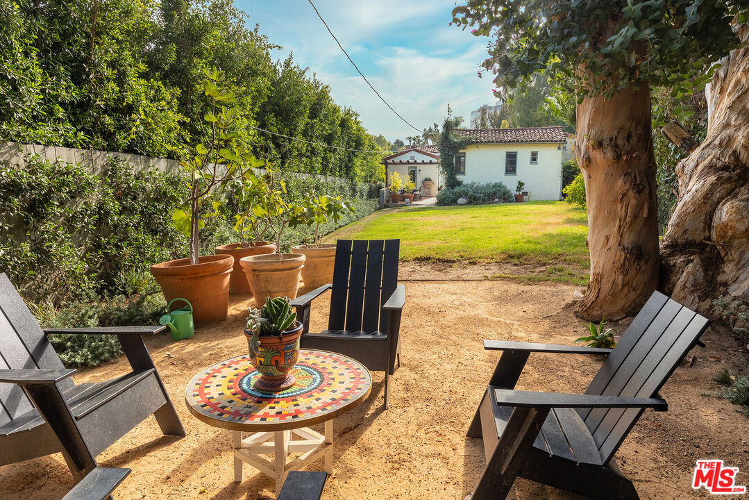 10346 Rochester Avenue Los Angeles, CA 90024 - Photo 18 of 19 a view of a patio with table and chairs potted plants and a palm tree