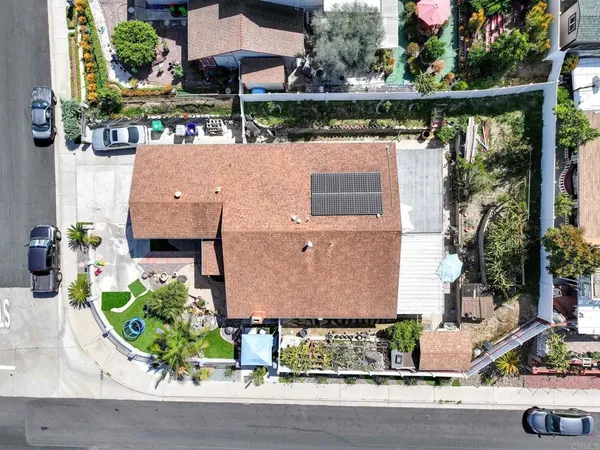 an aerial view of a house with a yard and a large tree