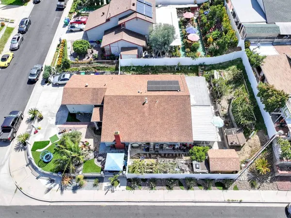 an aerial view of a house with garden space and street view