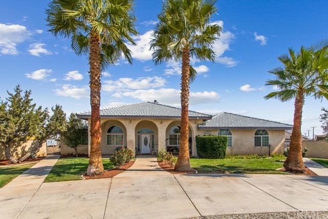 7725 Foley Road Oak Hills, CA 92344 - Photo 1 of 1 a view of a house with garden and trees